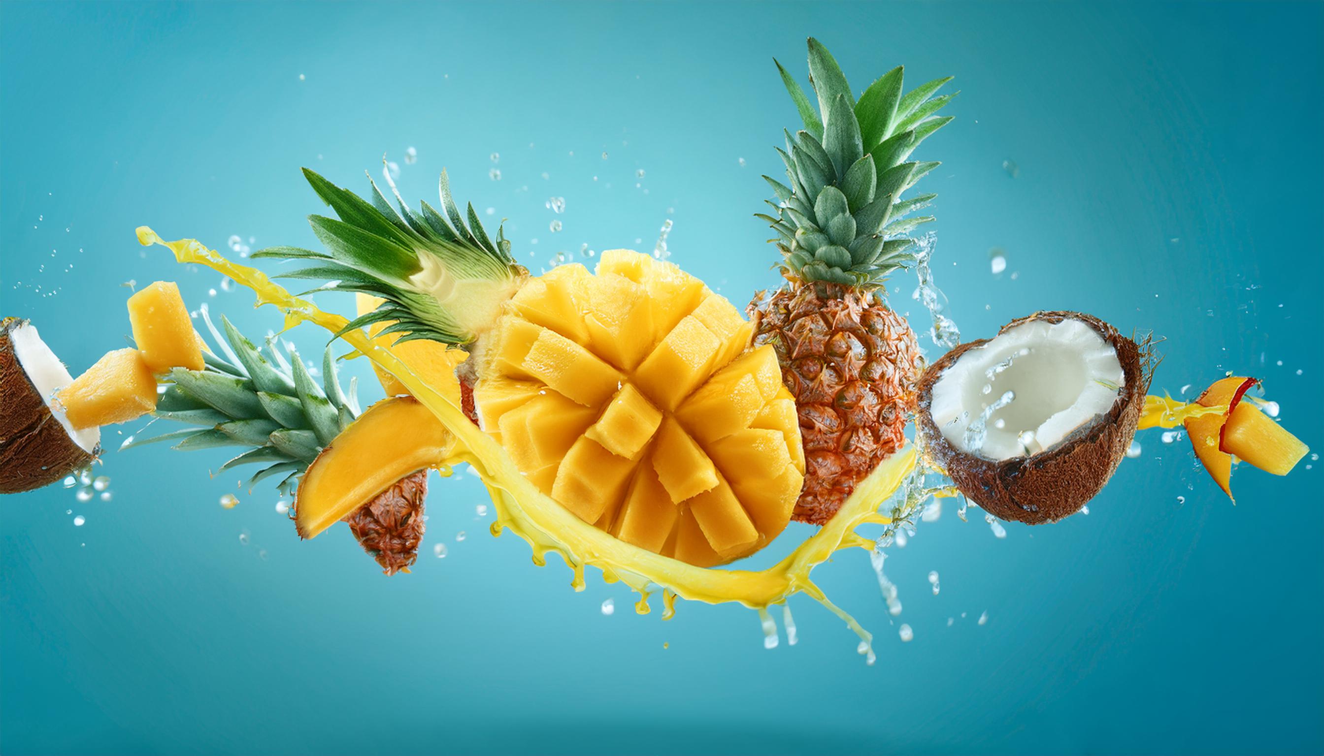 leader drops and huge splashes of juice with lot of pieces yellow mangoes, pineapples and 